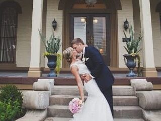 Bride and groom sharing a kiss on the front steps of a classic wedding venue Wedding planning consultation at The Pepin Mansion in New Albany, Indiana